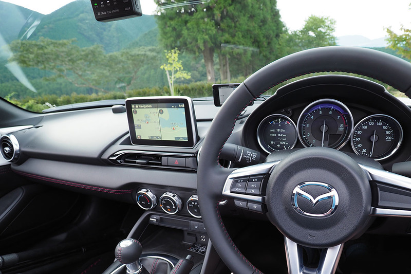 アンテナはリア右側にあり、ねじ込み式です。右写真はダッシュボード周辺の様子。メーター上部とフロントウィンドウの隙間は僅かで、ギリギリ手のひらが入るくらいの空間してないのでモノを置くのは難しいです。中央には純正のモニターが突き出ていて、このモニターは格納などすることができず、常にこの状態。この位置にも何かを設置しにくい感じ。左側はエアバッグなどもあり、ダッシュボードの傾斜がキツめで広さもあまりないので、ここも何かを設置するのには向きません。ちなみに、中央モニターの右後ろに写っているのはレーダー探知機で、モニター上方に見えるのはドライブレコーダー。これらの機器は、スペースやドライバー視線の関係で、この位置以外への取付ができませんでした。