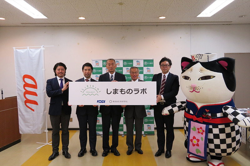 （左から）ルクサ コーポレート・コミュニケーション部長の山中竜太氏、KDDI CSR・環境推進室長の鳥光健太郎氏、大島町 町長の三辻利弘氏、大島町 商工会会長の鶴崎勝彦氏、NPO法人 離島経済新聞社 代表理事の大久保昌宏氏、地元のゆるキャラ「あんこ猫」