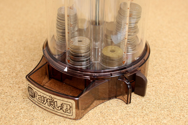 トイボックスの「貯金箱 銭別銀行 とりだし君」。上から入れた硬貨は自動的に選別＆ストックされます。本体上部を回転させて出したいコインを選び、本体横のツマミをつまんで離すと、ストックされた硬貨を1枚ずつ取り出せます。