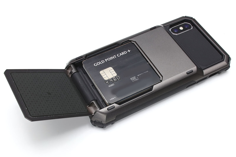 背面のフラップを開くとカード収納部があります。バネ式のような感じで、少し動かせばパカッと半自動開閉するタイプ。凸凹刻印のあるカード（一般的なクレジットカード）が5枚収まりました。カード収納部左右に凹みがあり、カードの出し入れもスムーズです。