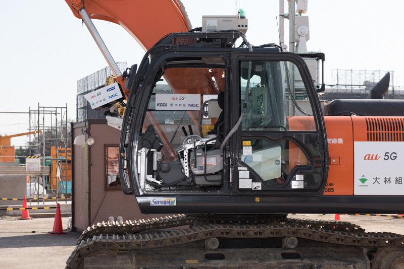 遠隔操作される無人のバックホー、日立建機「ZX210」。瓦礫の撤去などを想定したグラップル装備で、50cm角のコンクリートブロックの積み上げを披露