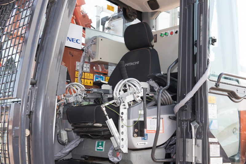 遠隔操作用の装置「サロゲート」が取り付けられた操縦席。そのまま乗り込んで操作することも可能。レバーの“遊び”など、オペレーターにとって重要な部分も一部はサロゲート経由で再現しているという