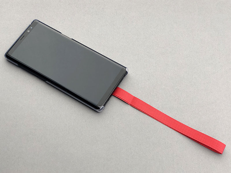 引っ張ってみたり吊してみたり。全然外れる感じがしません。さらに、製品情報ページにあった動画のマネをして、ブンブン振り回してみましたが……大丈夫でした♪　端末を机上に置いた状態でも、ループ部分が取っ掛かりになって端末を手に取りやすくてナイスです。