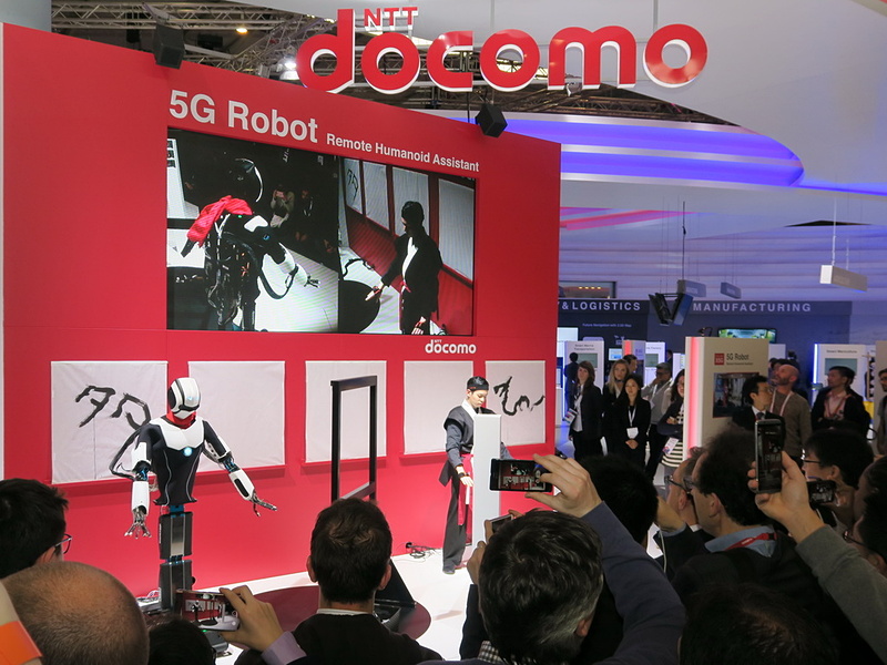 NTTドコモは5Gを使い、演者の動きに合わせて、ロボットが書道を披露する「ロボ書道」のデモを公開。デモの時間帯にはたいへんな人だかりができるほどの盛況ぶり
