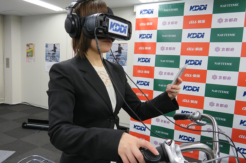 Gear VRを使って自転車ながらスマホの危険性を体験。左ハンドルに取り付けられたコントローラーのボタンを押してブレーキをかける