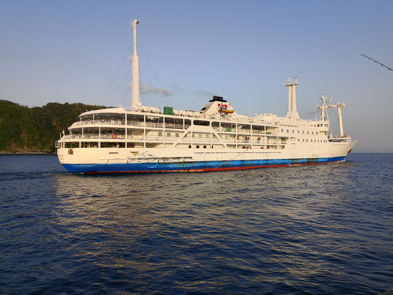 乗ってきた東海汽船のさるびあ丸。朝日を受けて出港していく。右に釣り竿が写り込んでいるのは、下船直後から釣りを開始したためだ