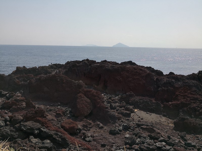 水平線が見えるせいで平行がとれていないことがバレバレだが……優良ポイントの「赤岩」。立てる場所は僅かで、すでに2人ほど入っている。真ん中に見えている岩は2～3階建ての建物ぐらいあり、道中は登山みたいになる。優良ポイントは往々にしてアプローチのハードルも高い。今回ここでは釣りをしていない