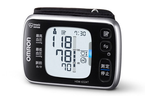 「手首式血圧計 HEM-6324T」は手首にややタイトに巻き、右下の測定/停止ボタンを押すだけで自動的に血圧が計測されます。巻き方や位置（高さ）に問題があれば知らせてくれたりも。この機種はバックライトが点灯し、暗くても視認性が抜群で便利です。
