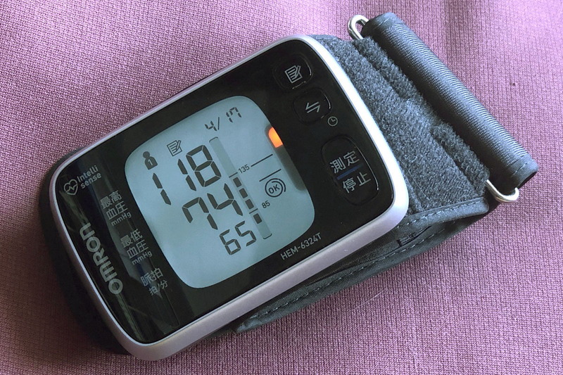 「手首式血圧計 HEM-6324T」は手首にややタイトに巻き、右下の測定/停止ボタンを押すだけで自動的に血圧が計測されます。巻き方や位置（高さ）に問題があれば知らせてくれたりも。この機種はバックライトが点灯し、暗くても視認性が抜群で便利です。