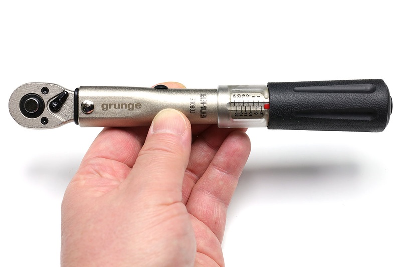 GRUNGE「コンパクトトルクレンチ」（<a href="http://amzn.asia/48RvDC2" class="strong bn" target="_blank">Amazon.co.jpへのリンク</a>）。自転車用のわりと一般的なトルクレンチで、握り部分を回して締め付けトルクをセットします。トルク指定範囲は2～24Nm。ボルトを締めていって指定トルクに達すると、ヘッド部分がカキンと音を立てて少し折れ曲がります。自宅に置いておくためのトルクレンチとしてフツーに便利ですが、トルク設定の正確さ・精密さに若干欠けるような気が。Amazonで6420円で売られています。