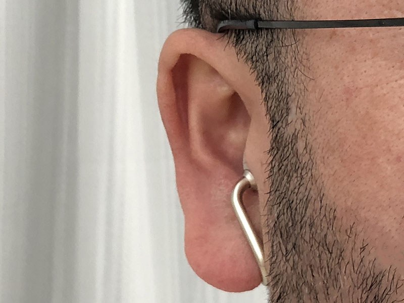 実際に装着した様子。前方から見ると、かなり目立ちにくいイヤホンであることがわかります。耳にかかる質量的な負担が分散されているためか、耳の一部だけにかかるような違和感がなく、長時間着けていても耳が痛くなりにくいと感じられます。