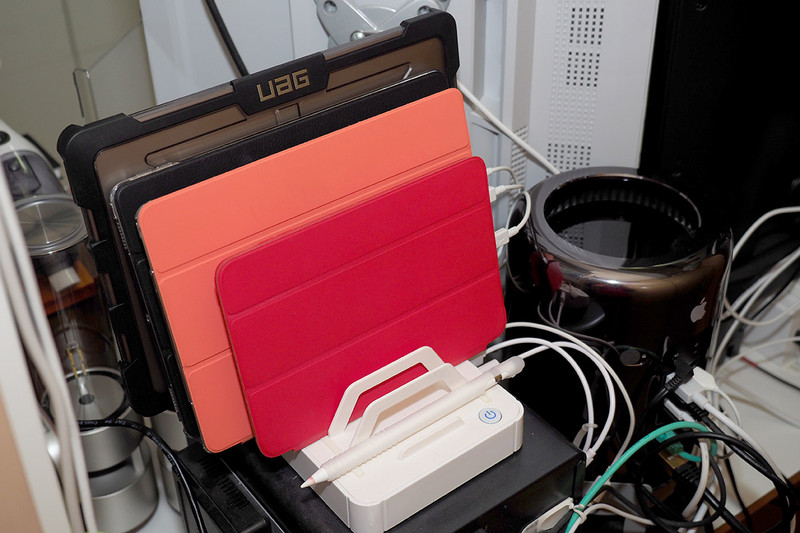 こちらはデスクトップPCのモニター後ろ側。左写真は、バックアップ用HDDアレイの上にノートPCを立て掛けたりタブレットを重ねたりして充電していた状態。右写真は、充電スタンド導入した後の様子。タブレット以上のサイズの端末を立てて充電すると、整理整頓＆見栄えスッキリになること以上に、使いたい端末をスッと引いて取り出せるという利便が大きいです♪