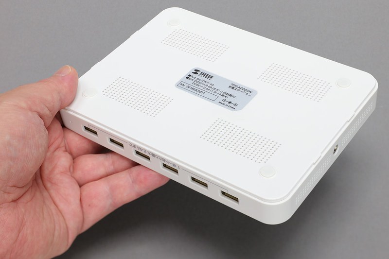 最大9.6A対応「700-AC020W」のベース部分。6つの充電用USBポートと仕切り板用スリットがあるだけの、非常にシンプルな台座部分です。裏面に滑り止め付き。短辺側面にACアダプター接続ジャックがあります。