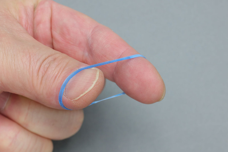 モビロンバンドは普通の輪ゴムと比べると薄く、滑らかな手触りです。普通の輪ゴムより伸びない感じですが、普通の輪ゴムの多くの用途をカバーできます。また、手で強く伸ばしてもなかなか切れないほどの強靱さがあります。