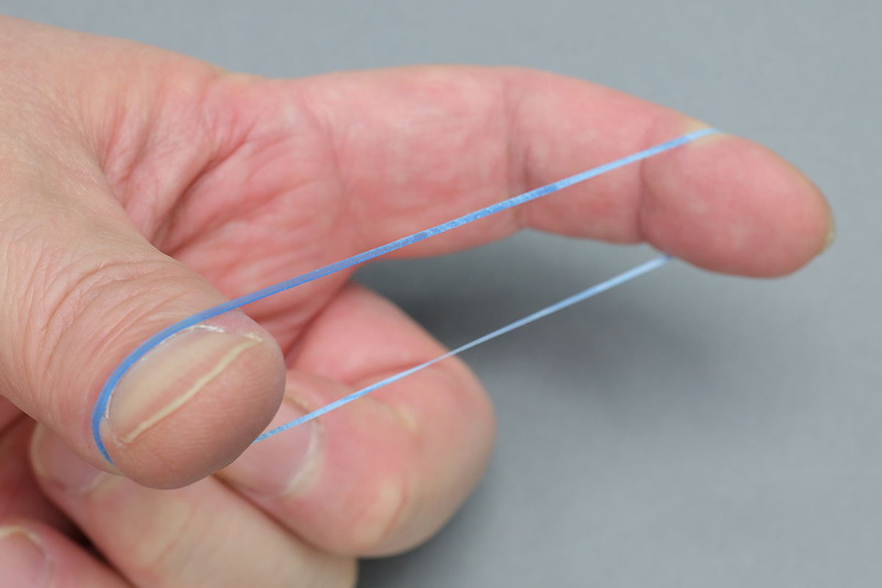 モビロンバンドは普通の輪ゴムと比べると薄く、滑らかな手触りです。普通の輪ゴムより伸びない感じですが、普通の輪ゴムの多くの用途をカバーできます。また、手で強く伸ばしてもなかなか切れないほどの強靱さがあります。