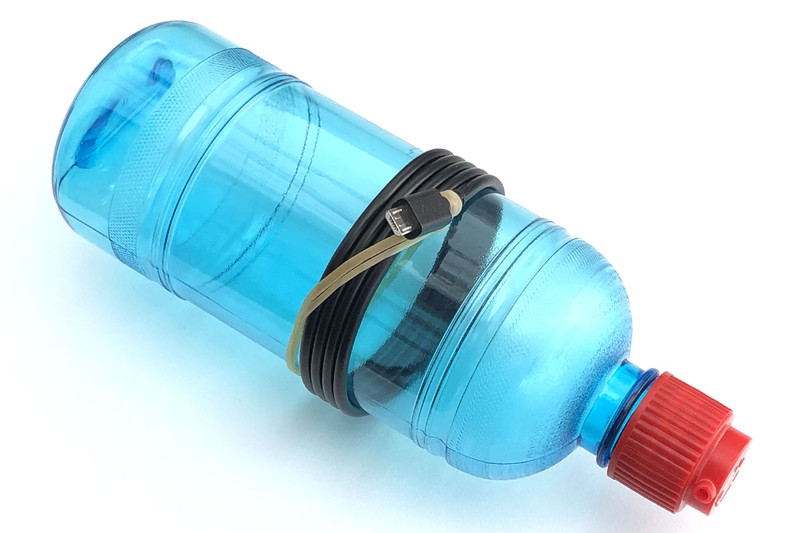 これは巻き癖が付いたケーブルを真っ直ぐに伸ばす作業です。必要なのは円柱状のボトルなどと輪ゴム。ケーブルの端に輪ゴムをくくりつけ、ケーブルをボトルに巻いて固定するだけ。