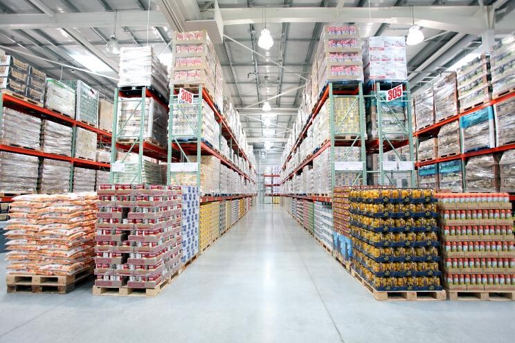 コストコホールセール・ジャパンの店舗内。大きな倉庫内に品物が大量に積まれています。多種多様な各社ブランド品が並び、どれも卸売り的な価格で販売されています。高品質な自社ブランド「カークランドシグネチャー（KIRKLAND）」製品も多数あり。