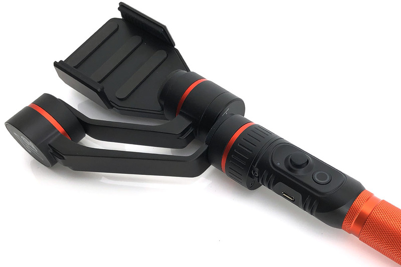 グリップ周辺。端末の方向を変えられるジョイスティックがあります。専用アプリと組み合わせると、これらボタンをより幅広い機能性とともに活用できます。電池は付属の18650リチウムイオン二次電池（3.7V）で、手持ちの同等品と交換しても使えました。電池はジンバル本体にセットしてUSB充電できます。なお、購入したパッケージに付属していた日本語説明書の電池挿入方向の説明が間違っていました（プラスマイナスが逆になっていました）。正しくは写真のように電池のプラス側がジンバル上方になるようにセットしますので、購入される方はご注意ください。