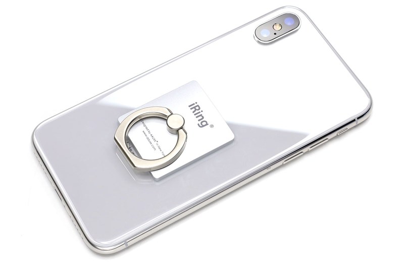 iRing LinkをiPhone Xに貼り付けた状態。やや力を込めてリング部を下方にスライドさせると、写真のように外れます。スマホ側に残るプレート状パーツの厚みは約1.8mm（実測値）。素材は樹脂なので、リングを外した状態ならワイヤレス充電ができそうです。