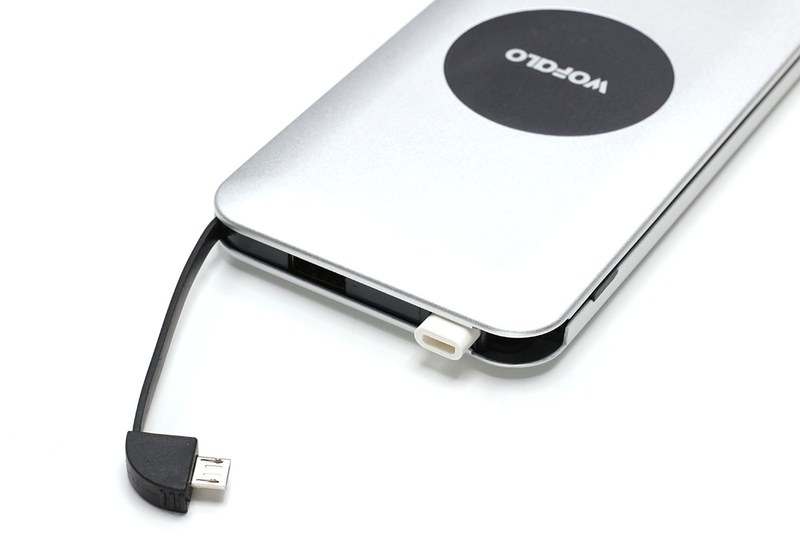 WOFALOのQi対応モバイルバッテリー（<a href="http://amzn.asia/5IUEybJ" class="strong bn" target="_blank">Amazon.co.jpへのリンク</a>）。Amazonで税込2799円。並んでいるスマートフォンはiPhone X。容量10000mAhのモバイルバッテリーで、電源ボタンを押して上にQi対応端末を載せると充電されます。給電用USBポートも搭載し、さらにmicroUSB端子の給電用ケーブルも内蔵。加えて、microUSBコネクタにはめて使うmicroUSB-Lightningアダプタが本体に収まっています。Qiを含め、3台の端末を同時に充電できます。バッテリーへの充電はmicroUSB対応USBケーブルで行います。