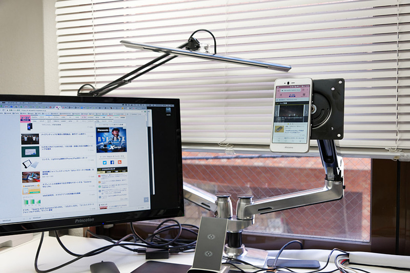 マグネット内蔵なので金属に貼り付けられる。別のスマートフォンをモニターアームに貼り付けてみた。仮想デュアルディスプレイ的な感じ？