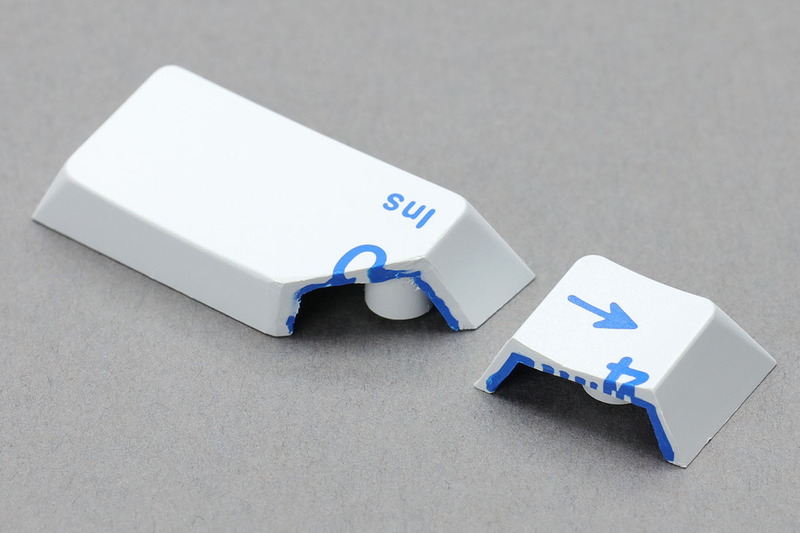 ダブルショットキーキャップをカットしたもの。いや～カットするのタイヘンでしたわ～って話はさておき、樹脂によるキートップ刻印は表面から裏面までほぼ貫通しています。厚みの半分くらいまでは刻印がそのままつながっているようです。なので、多少キートップが削れた程度では刻印が擦れたり消えたりすることはありません。しかしまあ凝った構造。どうやって製造するんでしょう？