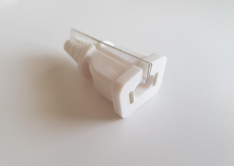 ACプラグに最初から挟まっていた透明プラスチック板の2つ折り。いったいその目的は……。