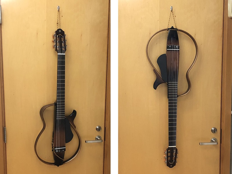 サイレントギターシリーズのボディは中空。フレームがあるだけの構造です。SLG200Nなどのクラッシックギタータイプには、糸巻き部も中空部分があります。そこにナイロン紐を通して輪をつくり、フックで吊して壁掛け収納～♪　撮影のためドアに吊していますが、いつもは棚の横側のフックに吊しています。