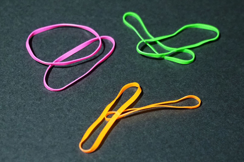 これは蛍光色の輪ゴム。UVライトを照射すると蛍光色が色鮮やかに光ります。