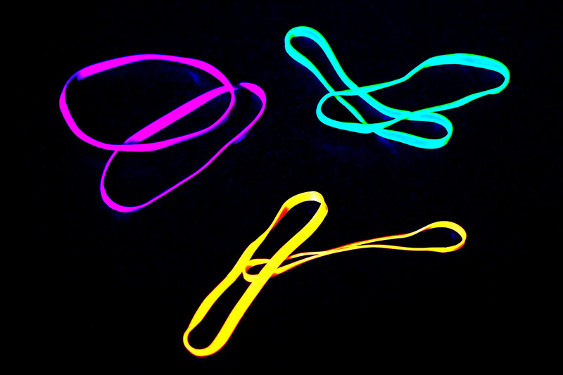 これは蛍光色の輪ゴム。UVライトを照射すると蛍光色が色鮮やかに光ります。