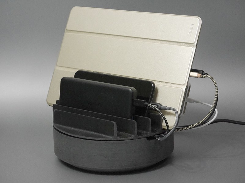 使用中の状態。スリットの幅がそこそこあるので、ケースを装着した状態のデバイスや、モバイルバッテリー（手前）なども立てられる