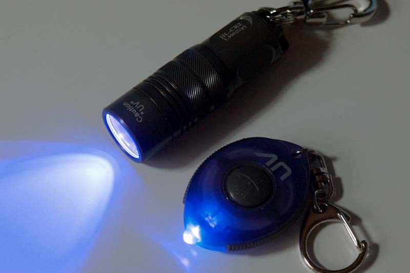 左写真は筆者が11年前に購入したUVレジン。釣り糸などの接着用ですが「11年経過した現在でも普通に使える」から驚きます。ただ、最近はより扱いやすいUVレジンが出ていて、それらばかり使用中。写真中央は11年前に購入した紫外線LEDライト。なんと1万6800円！　ですが、当時としては非常に高性能な紫外線LEDライトでした。最近ではコレ以上の性能のものが1000円以下で買えますネ。右写真は11年前の紫外線LEDライトを点灯させた様子。現在の製品と比べると光量はかなり少ない感じで、UVレジンの硬化にもやや時間がかかります。