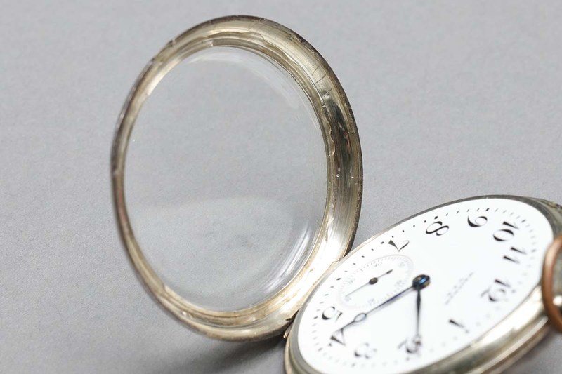 1928年につくられたと思われるWalthamの懐中時計。その後リペアされプラスチック風防が装着されましたが、それがカパッと外れてしまいました。そこで風防とリップ（風防外側の金属リング）の間にUVレジンを少量流して紫外線照射。風防をキッチリ固定できました。裏から観察すると「UVレジン盛りすぎ」の失敗が見えますが、観察しなければフツーに綺麗な仕上がりです。