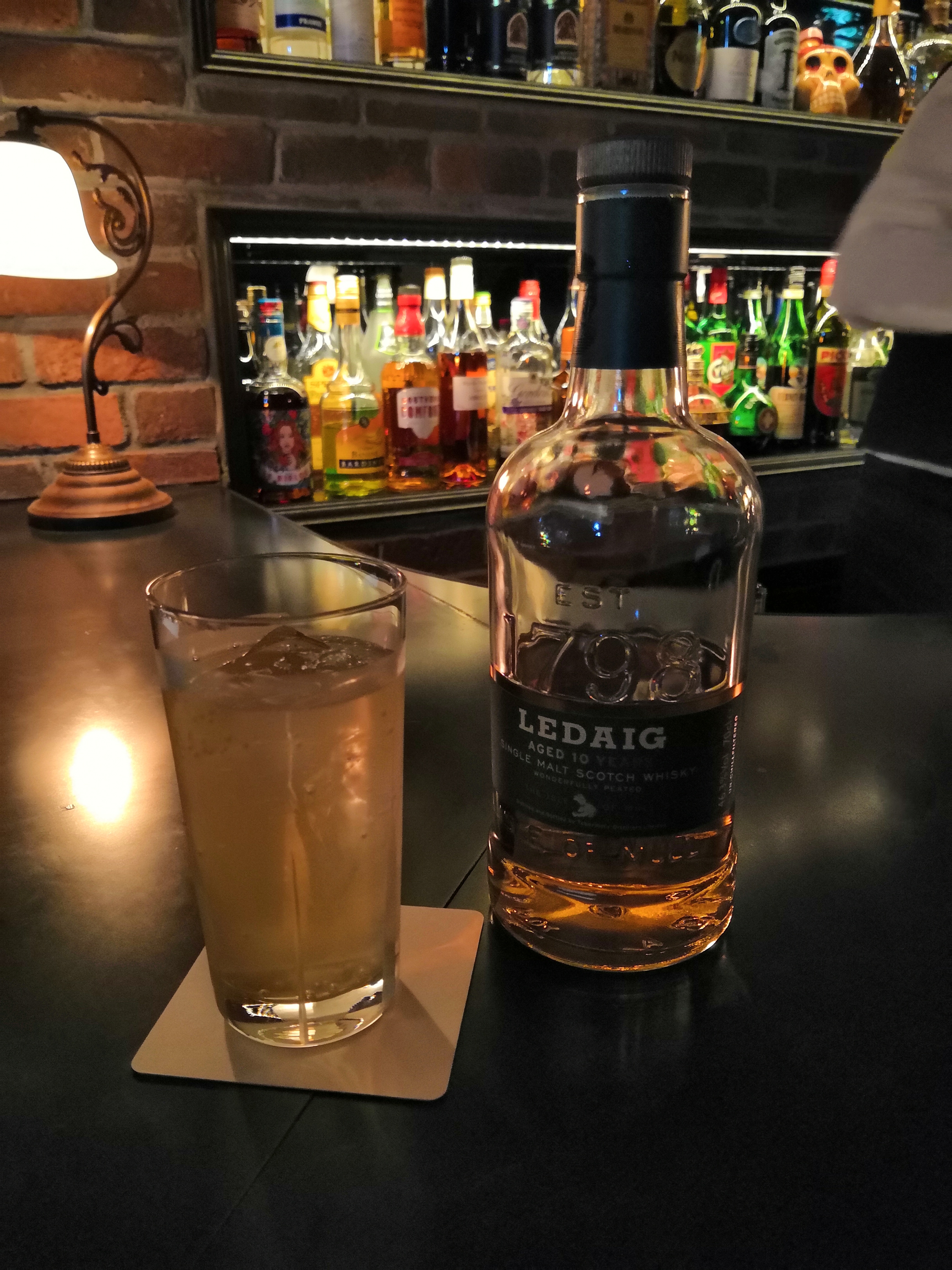 いつもの薄暗いバーで撮影。明るいところや中央のウイスキーのボトル、グラスなどがきれいに撮影できている（リンク先は3456×4608ドットのオリジナル画像）