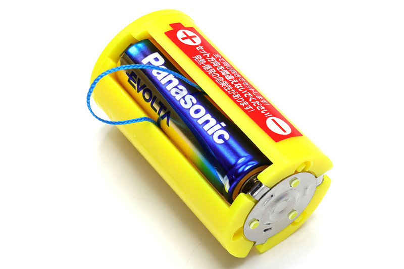 こんなふうに、細紐のリングに電池を通してからアダプターにセットすると、紐を引くだけで電池を抜くことができます。1本抜ければほかの電池は指で押し出せますので、細紐リングは1本の電池に付ければOKです。紐はなるべく細く強靱で、電気を通さないものを使いましょう。