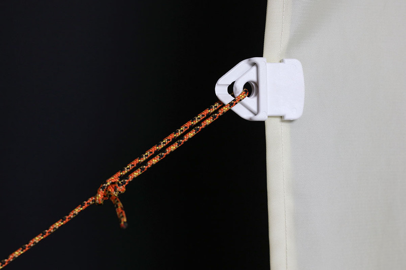 ホールドオン「マルチクリップ」シリーズの「MINI」の使用例。布の端を噛むように掴み、そのまま保持します。穴に紐を通して引っ張れば、タープやテント用フライシートなどを張ることもできます。引っ張れば引っ張るほど食い込むように布の端を噛み込み、その保持力は非常に強力。ただし、引っ張ると硬く固定されるので、平たい金属などでこじって外す必要があります。4個入りで950円でした。