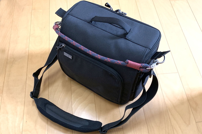 自作ストラップをカメラ用ショルダーバッグに装着した様子。このバッグには手で持つための取っ手がありますが、ファスナーを閉めた状態でないと取っ手を利用できません。別途こういうストラップがあったほうが断然便利です。