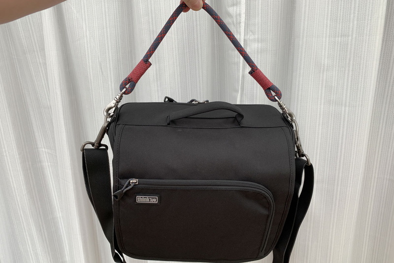 自作ストラップをカメラ用ショルダーバッグに装着した様子。このバッグには手で持つための取っ手がありますが、ファスナーを閉めた状態でないと取っ手を利用できません。別途こういうストラップがあったほうが断然便利です。