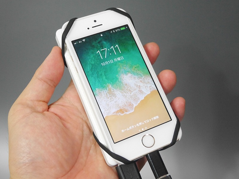 iPhone SEとモバイルバッテリーを束ねた状態。裏側から四隅に引っ掛けて固定する