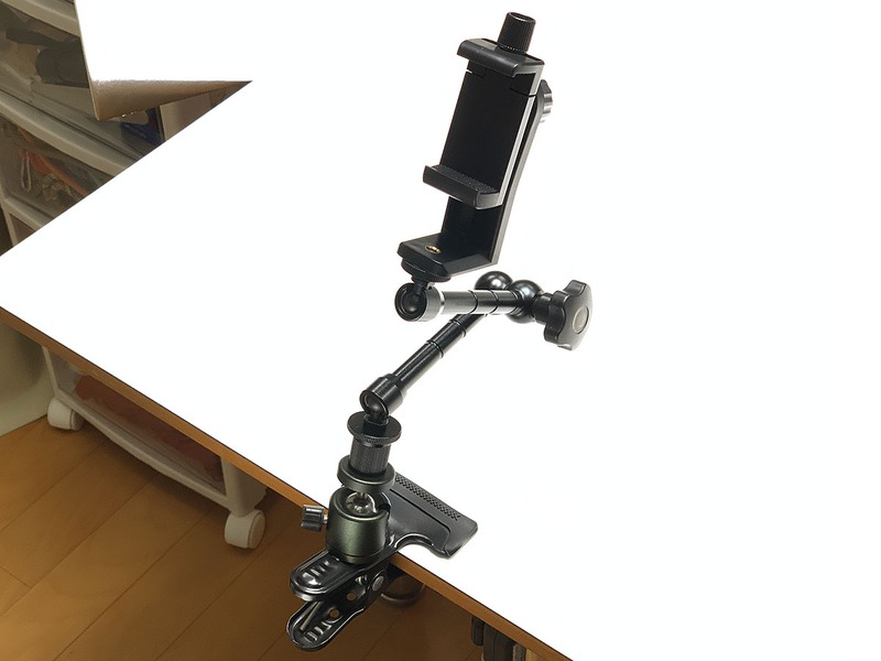 スマホの高さなど位置を容易に変えるには、少し機能性の高いアームなどとスマホホルダーを組み合わせて使いましょう。左はカメラ固定用のクリップに、自由に動き強固に固定できるアームをセットし、その上にスマホホルダーを装着したもの。右は、小型三脚に自撮り棒をセットし、その上にホルダーを装着したものです。これでもかなり手ブレ補正効果があります。もっと大きな三脚にスマホホルダーをセットして使ってもいいんですが、そうすると撮影機材がどんどん大がかりになり、スマホで撮影できるという手軽さが低減してしまいます。
