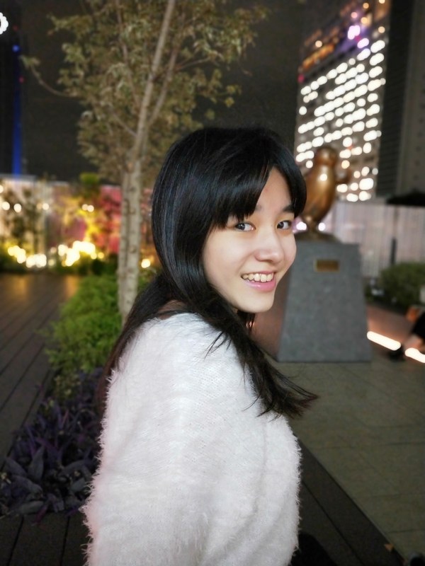 ポートレートモードで撮影。人物はきれいに撮影でき、背景の建物の明かりがうまくボケている。モデル：<a href="http://bonbon-famin.com/cn2/g01.html" class="strong bn" target="_blank">るびぃ</a>（ボンボンファミンプロダクション）　（リンク先は3456×4608ドット）