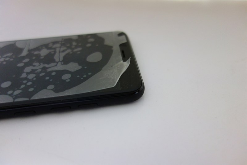 何度も貼り直し、端が曲がり、使うのを諦めたベロベロフィルムのアップ（EveryPhone PR付属品）