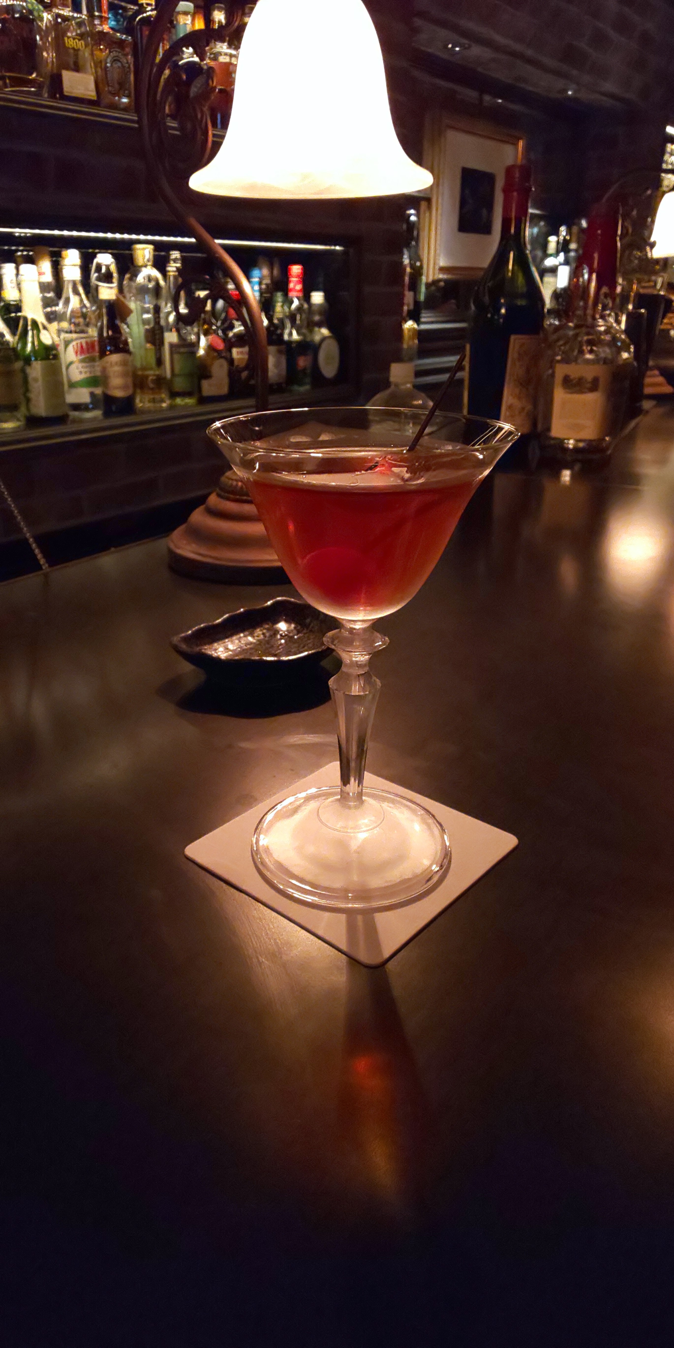 薄暗いバーで撮影。カクテルグラスがくっきりと撮影できている。色合いもバランスが取れている印象　※リンク先は2740×5480ドット