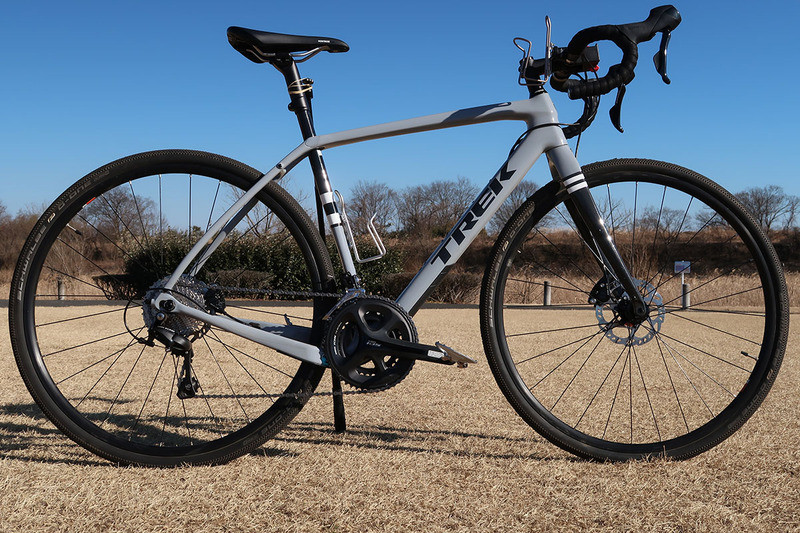 自立させた様子。ここでは自転車のシートポストにゴム止めしました。ゴムはモビロン（<a href="https://k-tai.watch.impress.co.jp/docs/column/korekori/1128410.html" class="strong bn" target="_blank">関連記事</a>）のほうが好適です。自転車乗車時にパンツの裾を留めるバンドでもいいですネ。サドル部をうまく使えば、ゴム止めとかも不要になったりします。