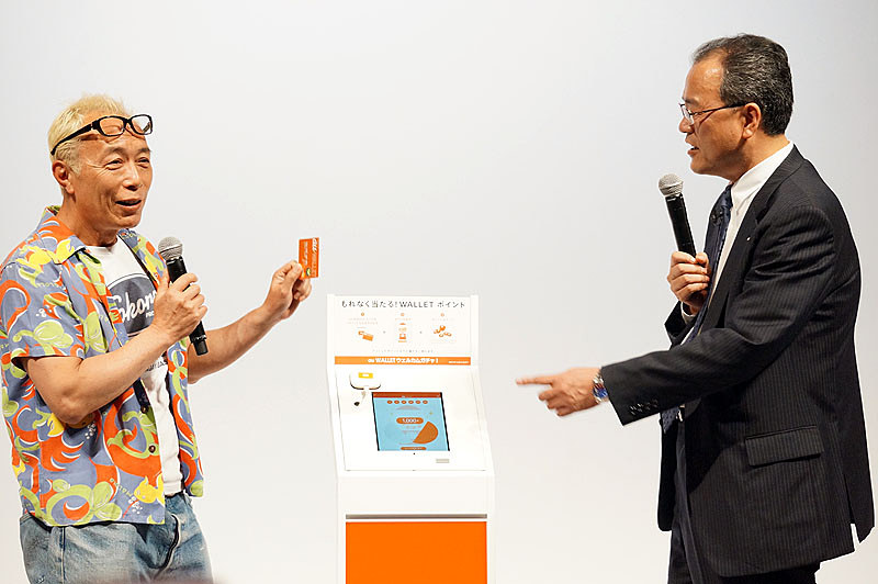 「au WALLET ウェルカムガチャ！」を紹介するau WALLETの発表会での一場面（2014年5月撮影）
