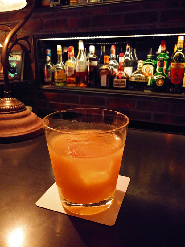 暗いバーで撮影した写真。カクテルの色合いも十分だが、やや背後のランプに助けられた印象。