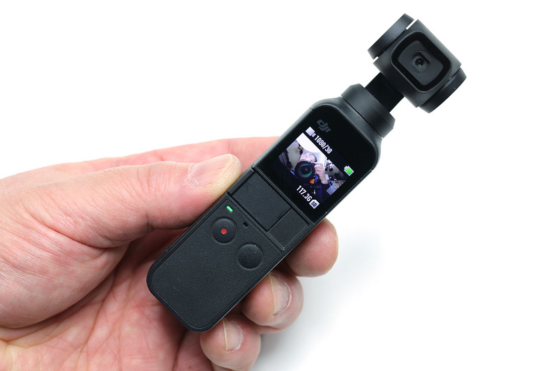 Osmo Pocketのサイズは高さ121.9×幅36.9×厚さ28.6mmで、質量は116g。上部がスタビライザー・カメラ部で、小さな液晶モニターと操作ボタンを備えます。オレンジ色のカメラはオリンパス「TG-860」（<a href="https://www.olympus-imaging.jp/product/compact/tg860/" class="strong bn" target="_blank">公式ページ</a>）で、わりと標準的なサイズのコンパクトデジカメ。Osmo Pocketこういったコンデジよりもさらにコンパクトなカメラです。