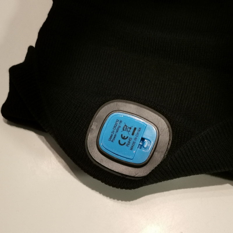 ニット帽の折り返し部分を開き、背面からバッテリーを交換する