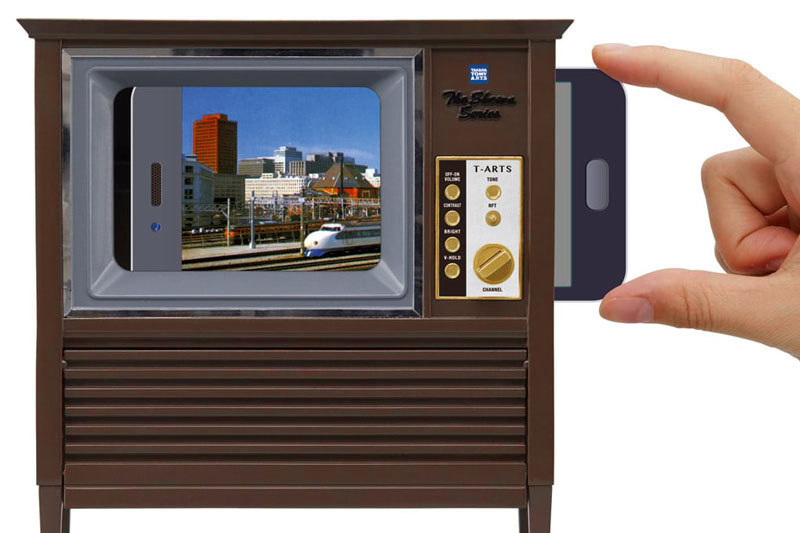 昭和スマアトテレビジョンはスマートフォンをセットできる「テレビ風のガワ」です。もちろん電池などは不要。下側が開いて小物を収納できたり、木目調がわりとリアルだったり、つくりもイイ感じ。専用アプリを使い、好みのネット動画を「テレビ風のガワの画面枠内に合わせて再生」することが可能です。サイズは幅160×高さ173×奥行き65mm。対応スマートフォンは下表のとおり。