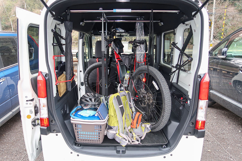 左写真はN-BOX+にクロスバイクタイプe-bikeのミヤタ「CRUISE」(<a href="http://www.miyatabike.com/miyata/lineup/cruise/cruise.html" class="strong bn" target="_blank">公式ページ</a>)を載せた様子。N-BOX+も後部がフルフラットになりますので、自転車用トランスポーターとしても好適です。右はN-VANにMTBタイプe-bikeのミヤタ「RIDGE-RUNNER」(<a href="http://www.miyatabike.com/miyata/lineup/ridge_runner/ridge_runner.html" class="strong bn" target="_blank">公式ページ</a>)を載せた様子。上下左右ともさらに余裕がありますので、車格のあるMTBでも余裕をもって積めます。もちろんタイヤを外さずに。試してはいませんが、助手席を倒さず、後部のフラット部分だけ使い、MTBが2台乗りそうな気がします。タイヤ外せば3台のMTBが載るかも?